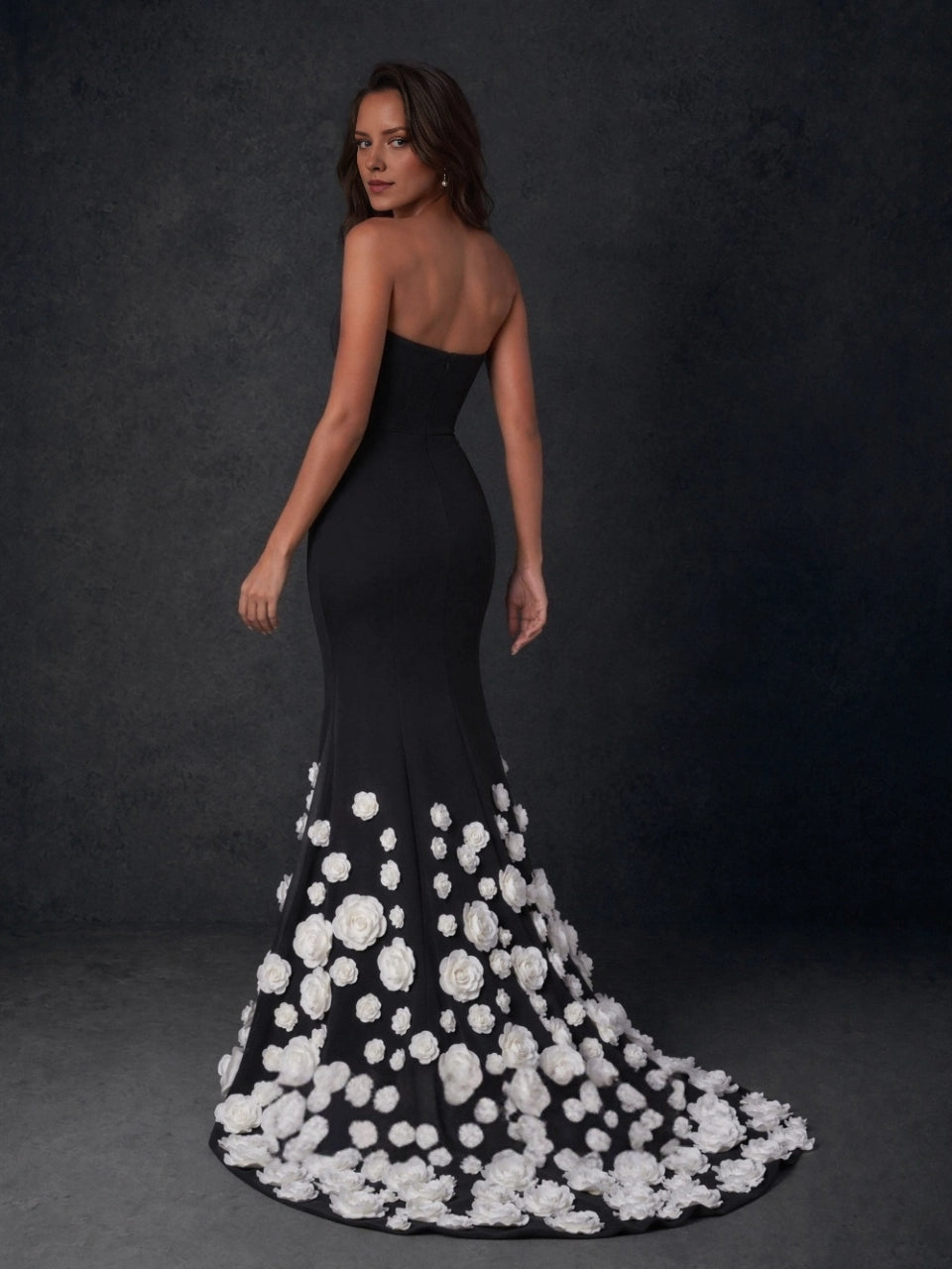 Back view of Vedress black mermaid evening dress with a straight mid-back edge and white floral appliqués covering the train.